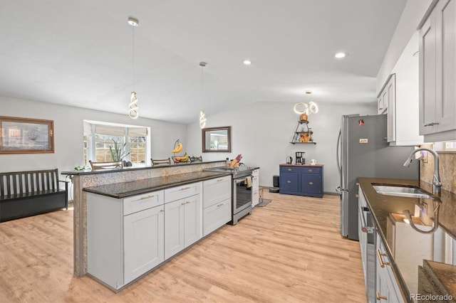 kitchen featuring light wood-style flooring, white cabinets, stainless steel appliances, and a sink