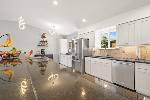 kitchen with a sink, dark stone countertops, tasteful backsplash, recessed lighting, and stainless steel appliances