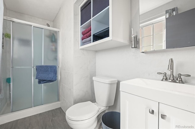 full bathroom with vanity, toilet, wood finished floors, and a stall shower