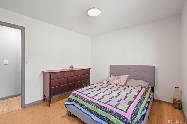 bedroom featuring wood finished floors and baseboards