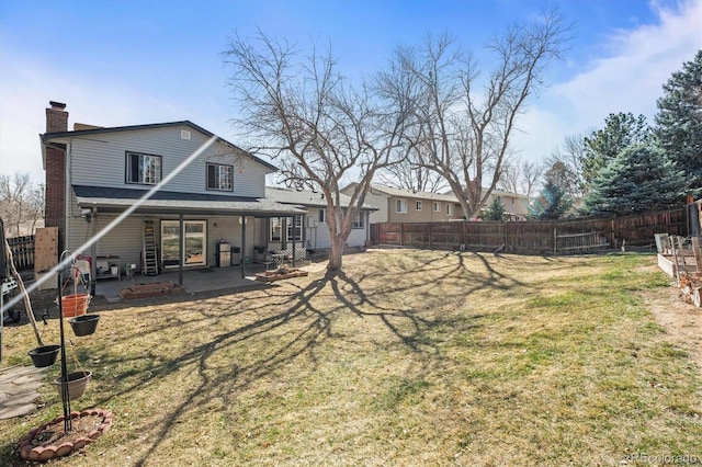 exterior space with a patio, a yard, a fenced backyard, and a chimney