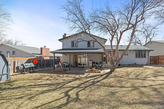 back of property with a yard, a patio, a fenced backyard, and a chimney