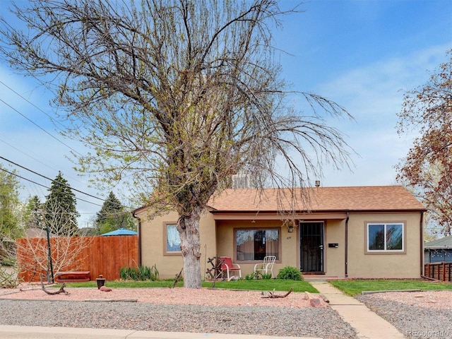 675 S Quivas St, Denver, CO 80223 - ranch-style house featuring covered porch, fence, and stucco siding
