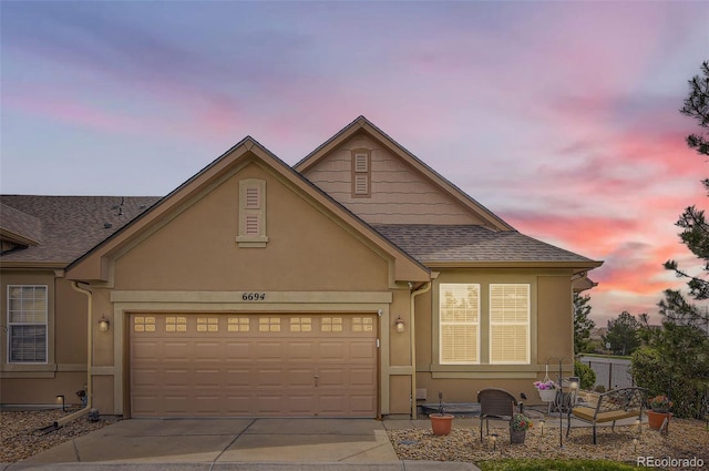 view of front of home featuring driveway, a garage, and stucco siding