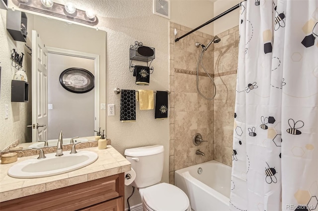 bathroom with a textured wall, toilet, shower / bath combination with curtain, and vanity