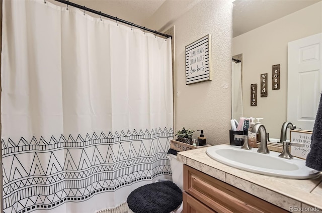 bathroom featuring a textured wall and vanity