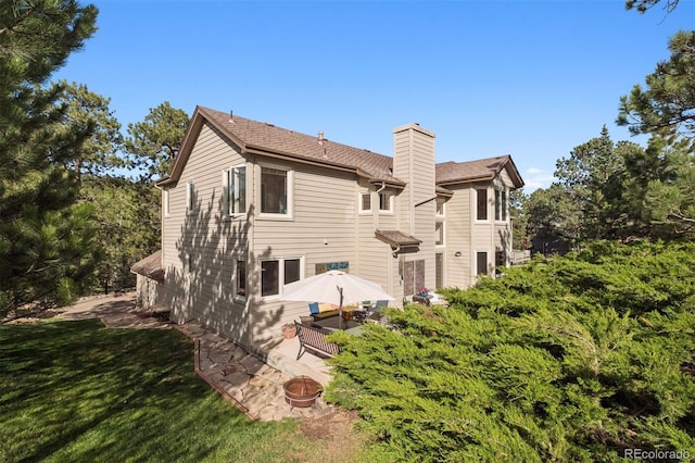 31402 N Bermuda Dunes Dr, Evergreen, CO 80439 - back of house with a chimney, a yard, and a patio area