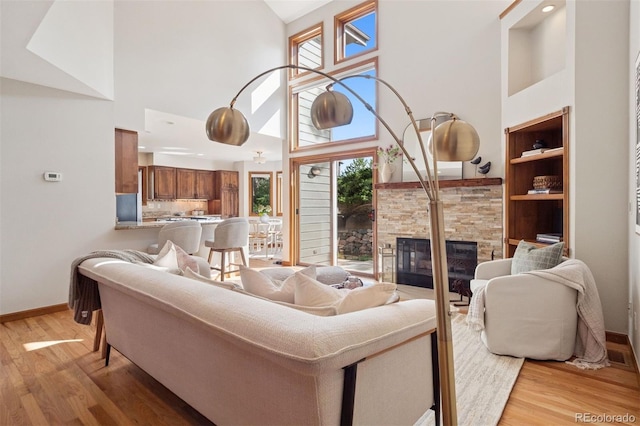 31402 N Bermuda Dunes Dr, Evergreen, CO 80439 - living area featuring a high ceiling, a stone fireplace, light wood-style floors, and healthy amount of natural light