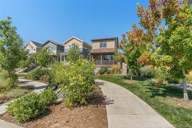 view of front of home featuring a porch, a residential view, and a front yard