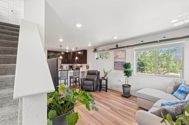 living room with stairway, baseboards, recessed lighting, and light wood-style flooring