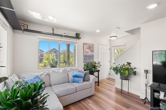 living area featuring baseboards, recessed lighting, and light wood-style flooring