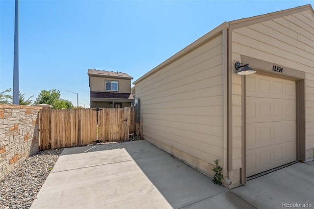 view of property exterior with fence and a patio area