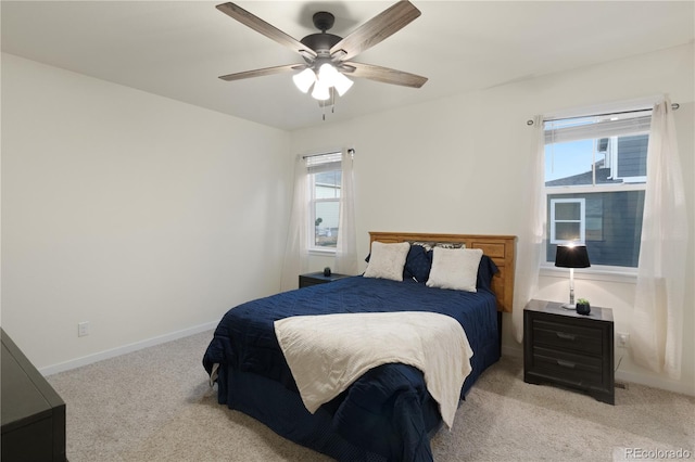 carpeted bedroom with multiple windows and ceiling fan