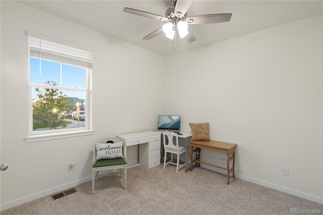 carpeted office space featuring ceiling fan