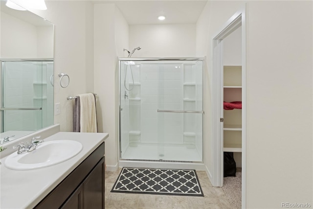 bathroom with vanity, a shower with door, and tile patterned floors