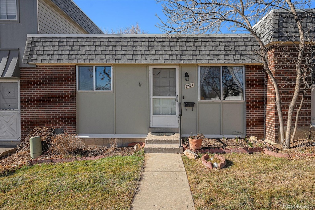 property entrance featuring a lawn