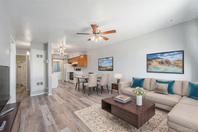 living room with ceiling fan and light hardwood / wood-style floors