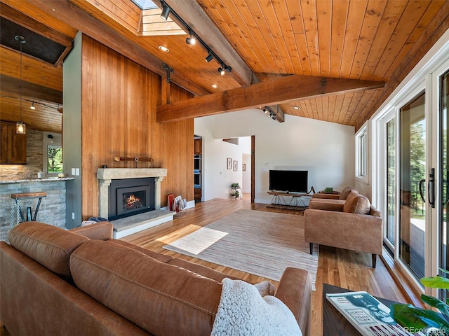 31756 Buffalo Park Rd, Evergreen, CO 80439 - living room with rail lighting, wood ceiling, a lit fireplace, and wood finished floors