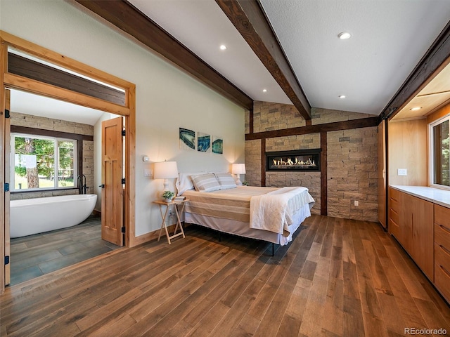 31756 Buffalo Park Rd, Evergreen, CO 80439 - bedroom featuring wood finished floors, beamed ceiling, a fireplace, and baseboards