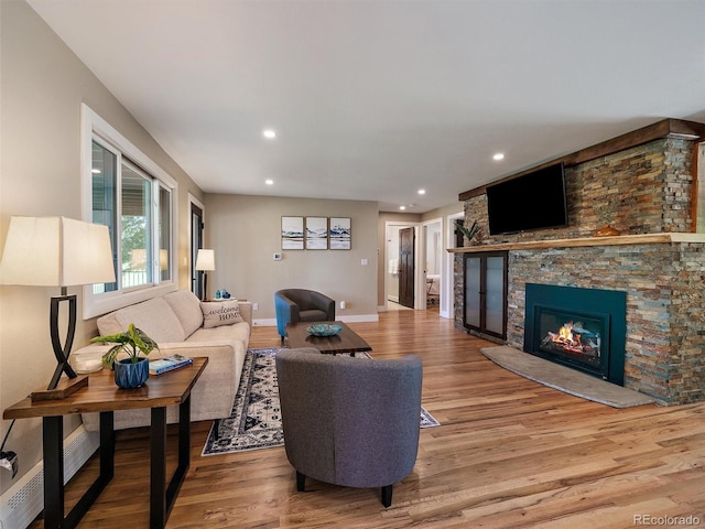 31756 Buffalo Park Rd, Evergreen, CO 80439 - living room with wood finished floors, recessed lighting, a stone fireplace, and baseboards