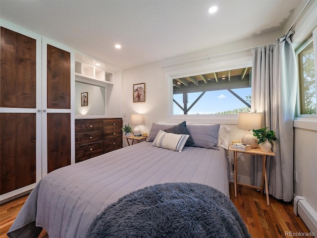 31756 Buffalo Park Rd, Evergreen, CO 80439 - bedroom with a baseboard heating unit, wood finished floors, multiple windows, and recessed lighting