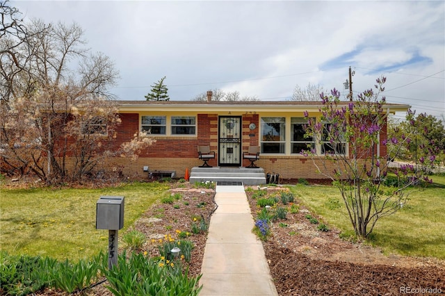 view of front of home with brick siding and a front lawn