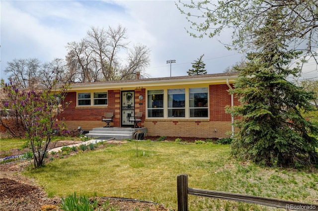view of front of home featuring brick siding and a front yard