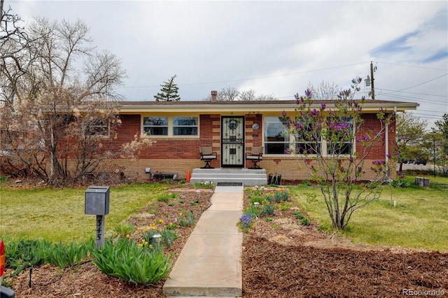 view of front of house featuring brick siding and a front yard