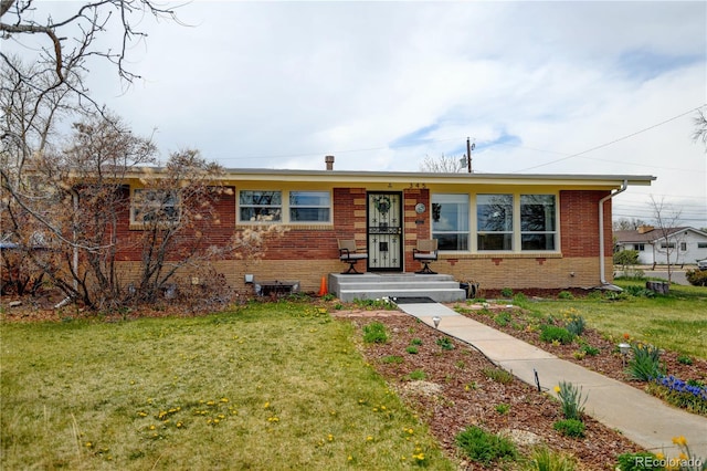 view of front of home with a front lawn and brick siding