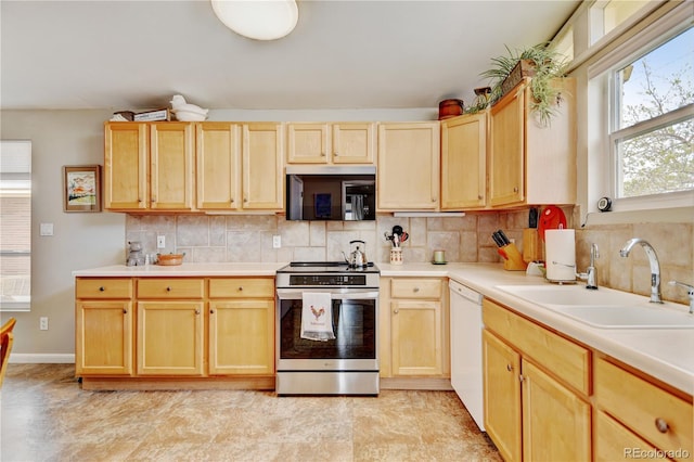 kitchen featuring electric stove, a sink, light brown cabinetry, dishwasher, and light countertops