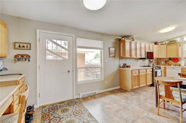 kitchen with stainless steel appliances, decorative backsplash, and light countertops
