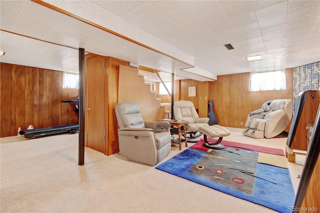 below grade area with wood walls, carpet, and stairs