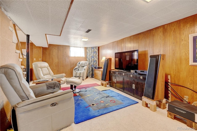 carpeted living area with wood walls