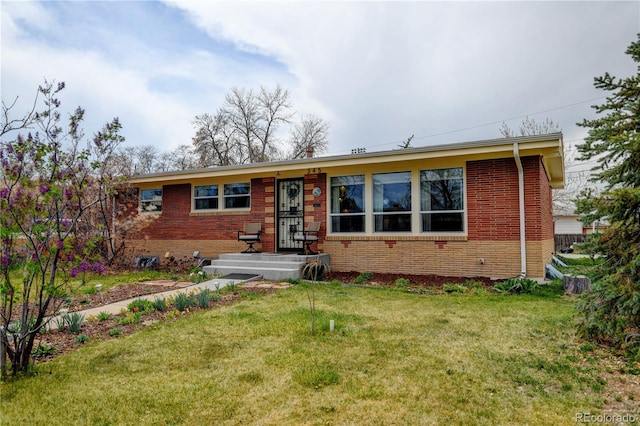 ranch-style home featuring brick siding and a front lawn