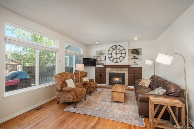 living room with wood finished floors, a fireplace, and baseboards