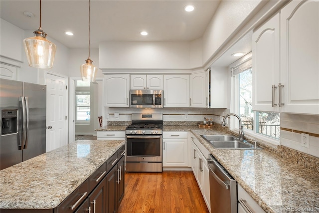 kitchen with appliances with stainless steel finishes, a sink, white cabinets, and recessed lighting