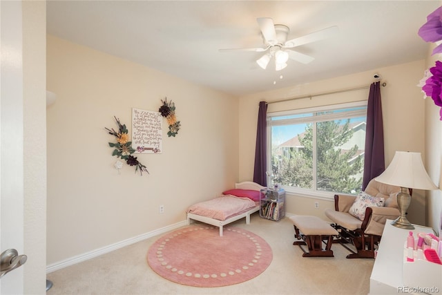 living area featuring carpet flooring, ceiling fan, and baseboards