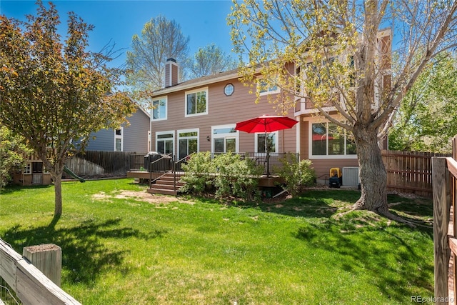 rear view of house featuring a chimney and a deck