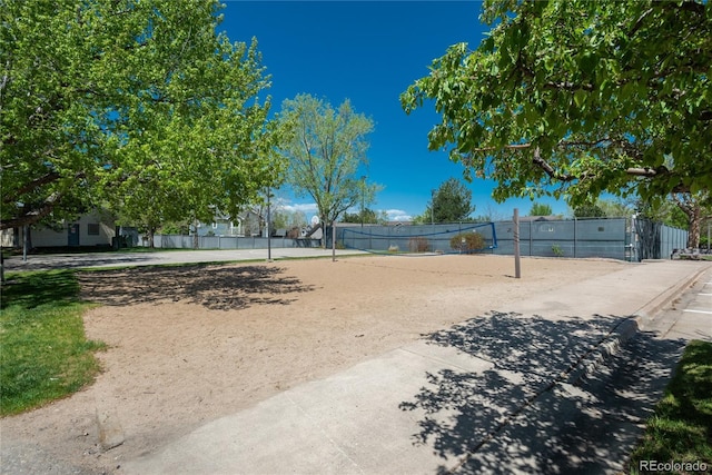 view of yard featuring volleyball court and fence