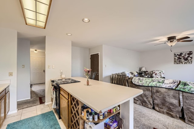 kitchen with baseboards, ceiling fan, open floor plan, black range with electric stovetop, and light countertops