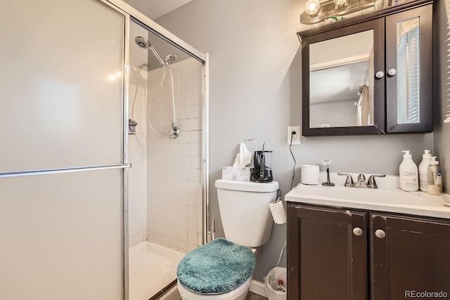 bathroom with toilet, a shower stall, and vanity