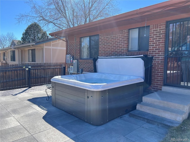 view of patio / terrace with entry steps, fence, and a hot tub