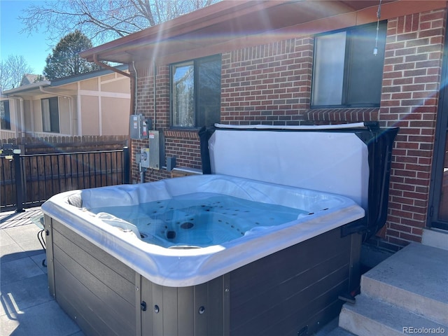 view of patio featuring fence and a hot tub