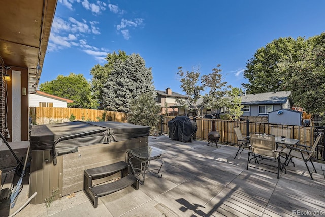 wooden deck with a patio, a fenced backyard, grilling area, outdoor dining space, and a hot tub