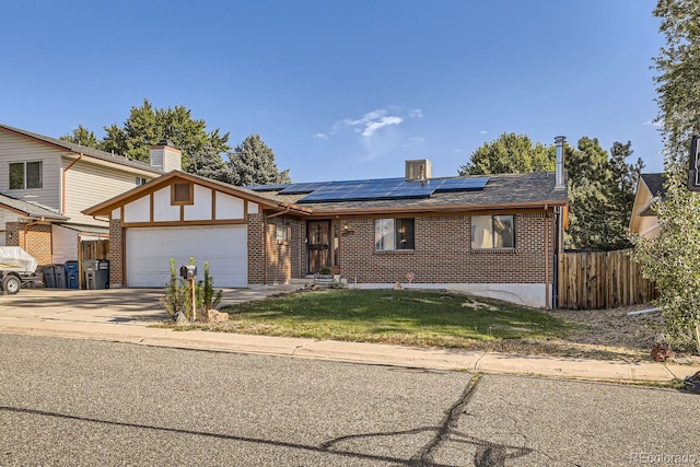 view of front of home with driveway, brick siding, fence, and roof mounted solar panels