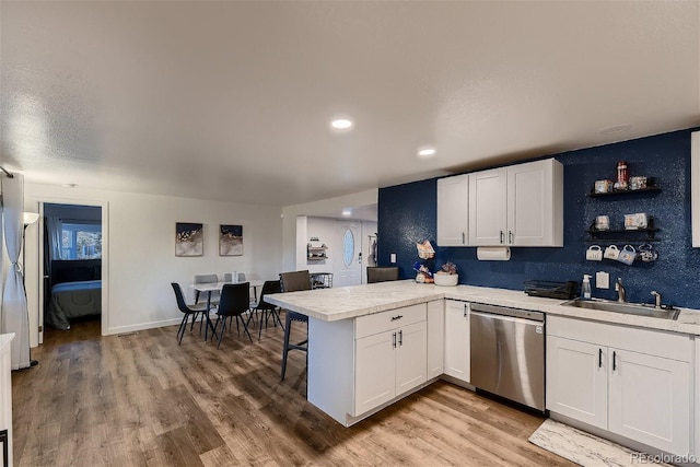 kitchen featuring white cabinets, dishwasher, kitchen peninsula, and sink