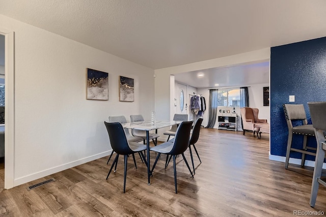 dining space with hardwood / wood-style flooring