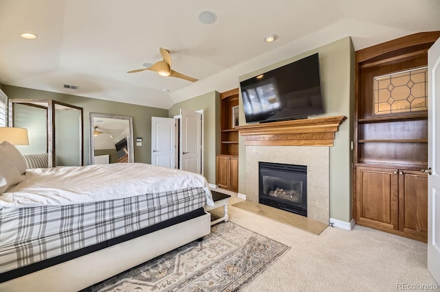 bedroom with a fireplace, lofted ceiling, recessed lighting, light colored carpet, and visible vents