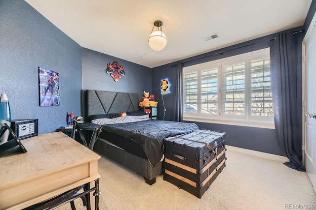 bedroom featuring carpet floors, baseboards, visible vents, and a textured wall