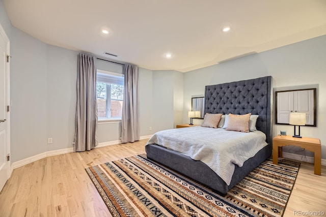 bedroom with baseboards, visible vents, and light wood-style floors